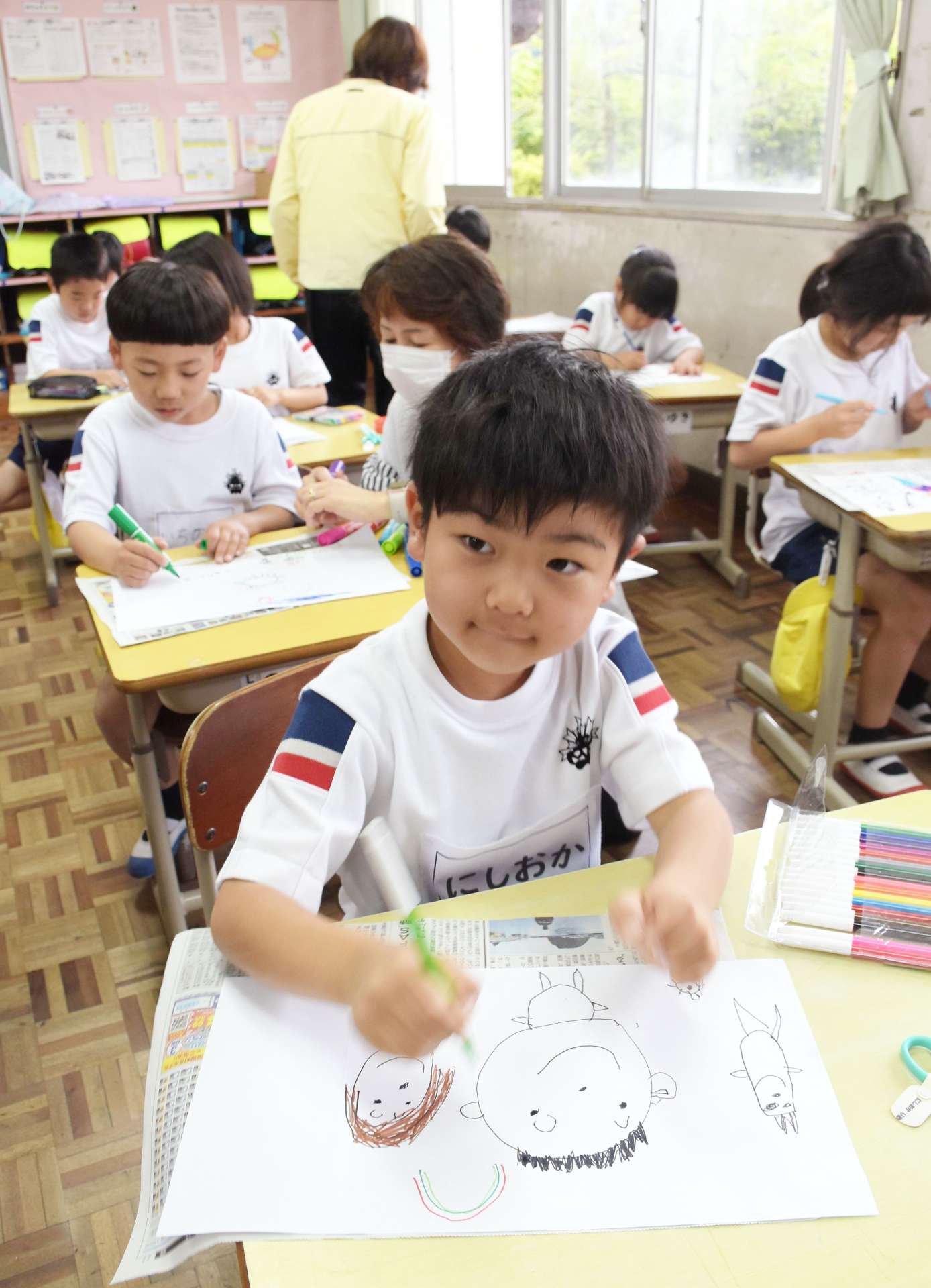 ペットボトル灯籠用の絵を描く児童＝２８日、志布志市の志布志小