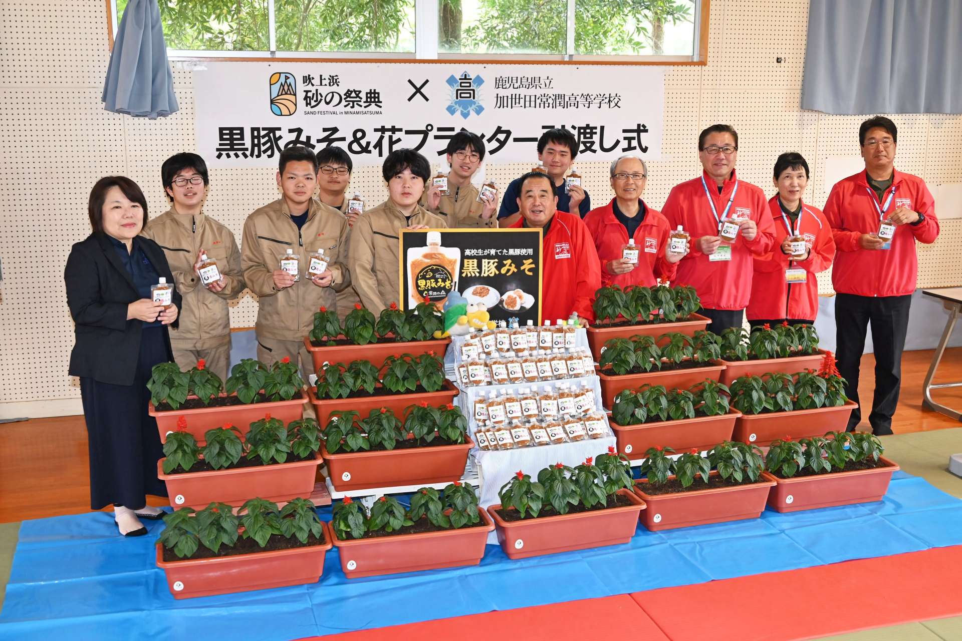 記念撮影する吹上浜砂の祭典実行委員会と加世田常潤高校生ら＝３０日、南さつま市の同校