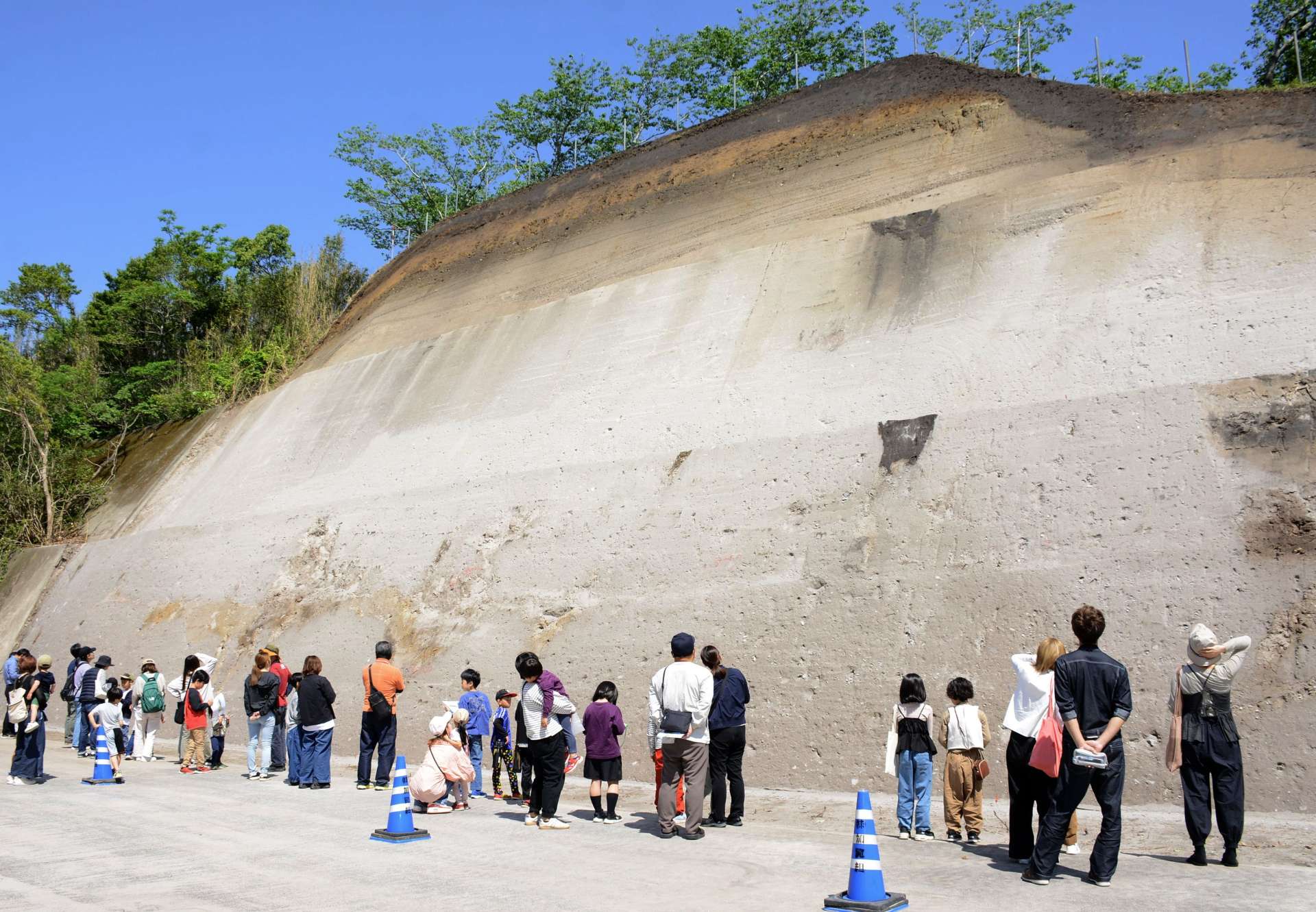 体育館裏の地層を観察する参加者＝南九州市の川辺小学校