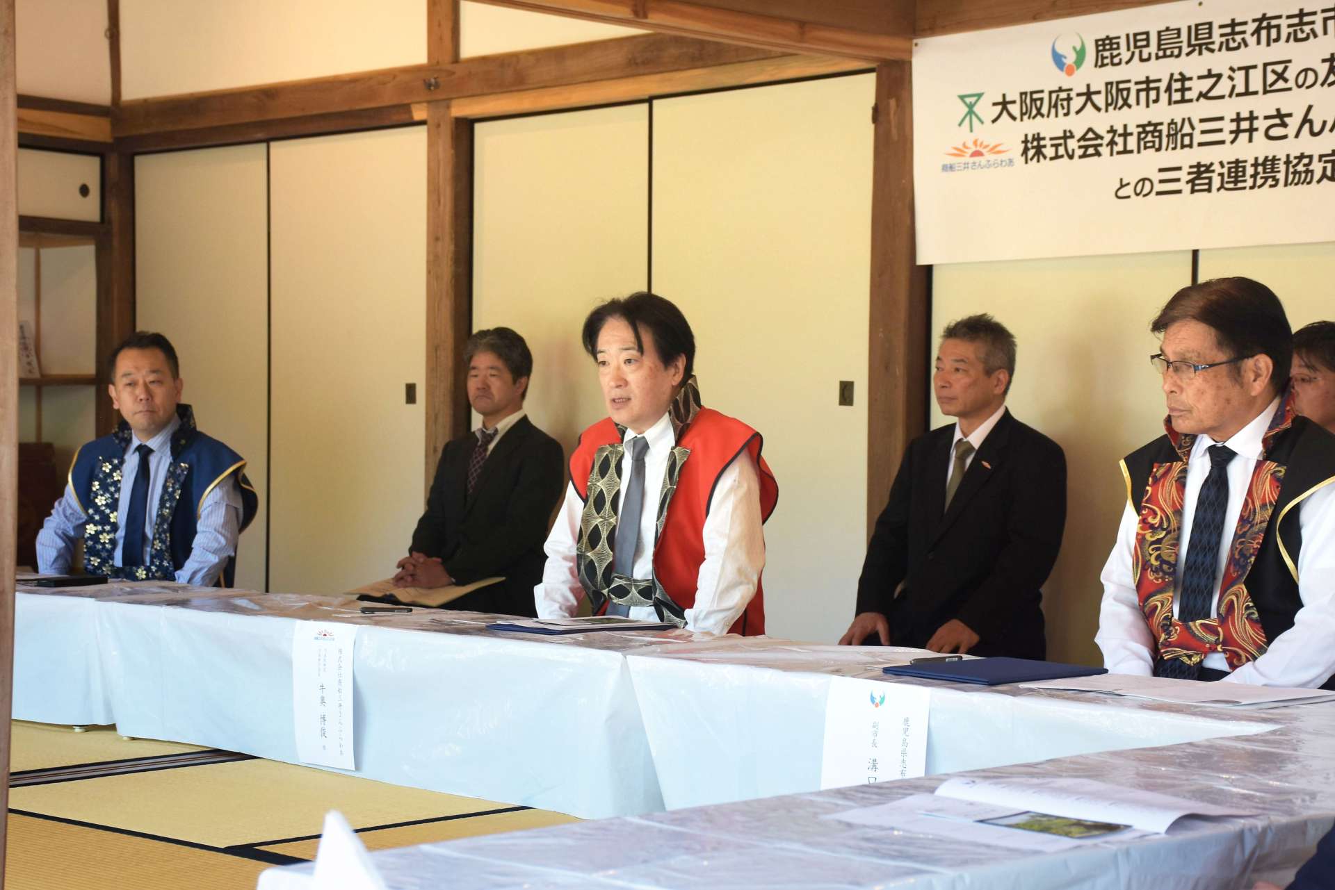志布志市、大阪市住之江区と連携協定を結び、あいさつする商船三井さんふらわあの牛奥博俊さん（中央）＝４月２９日、志布志市の福山氏庭園