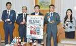 県産紅茶葉を１００％使用した紅茶飲料のＰＲで表敬訪問したアサヒ飲料の高橋徹マーケティング二部長（右から２人目）ら＝８日、県庁