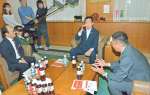 県産紅茶葉を１００％使用した紅茶飲料を試飲する塩田康一知事（中央）＝８日、県庁