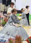 ドレスに合わせて生花で髪飾りを作る鹿児島県美容専門学校生＝指宿市のフラワーパークかごしま