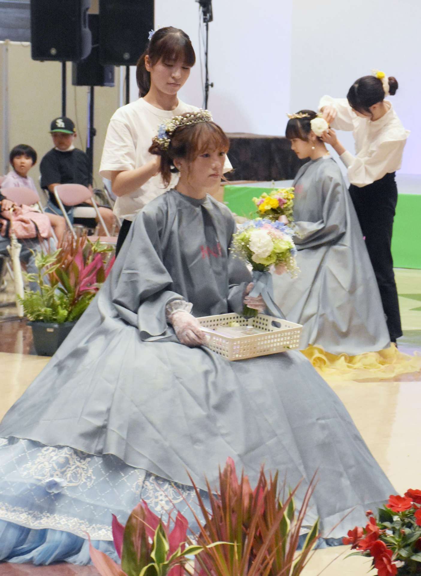 ドレスに合わせて生花で髪飾りを作る鹿児島県美容専門学校生＝指宿市のフラワーパークかごしま