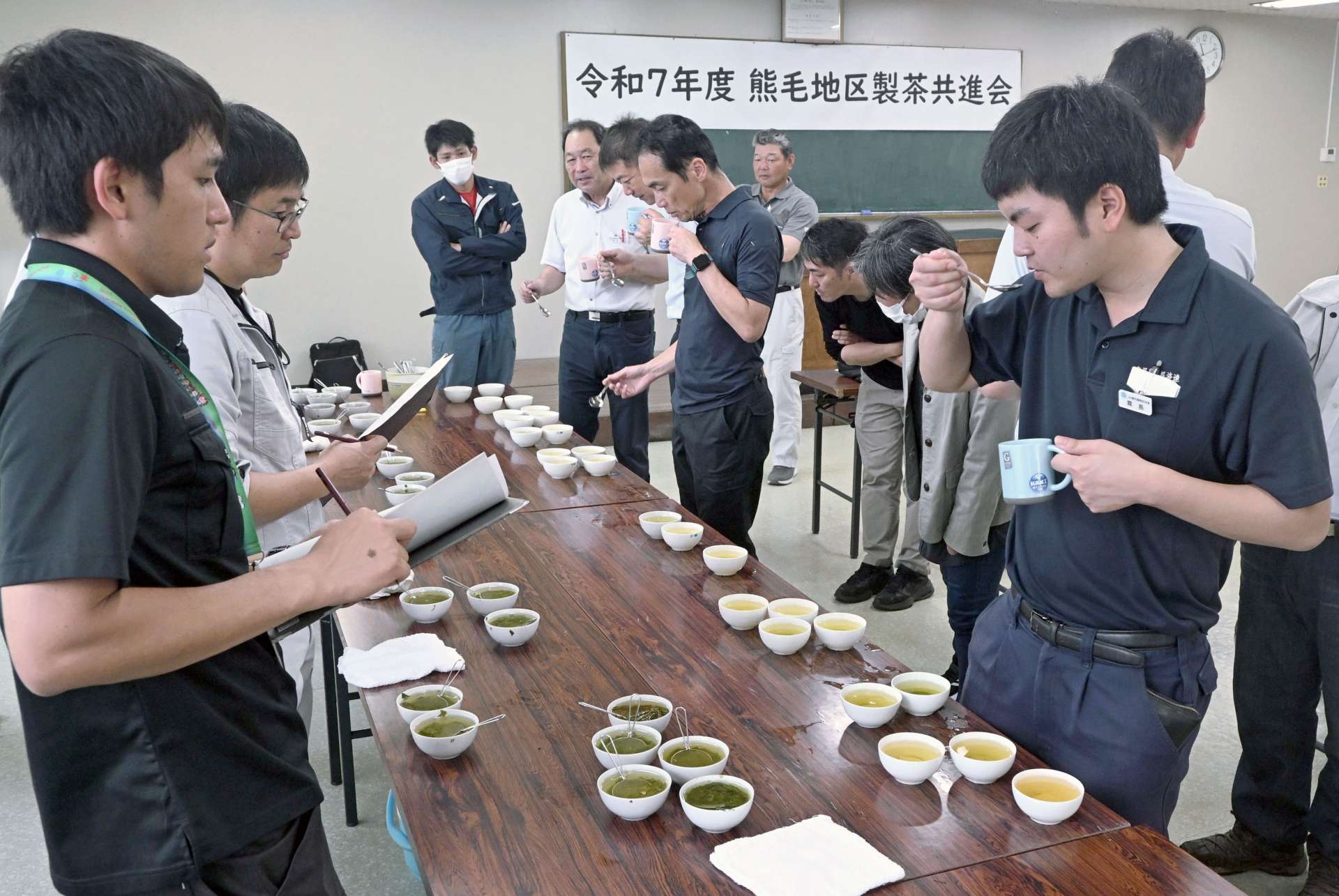 一番茶の味や香りを確かめる審査員や農家ら＝９日、西之表市のＪＡ種子屋久西之表支所