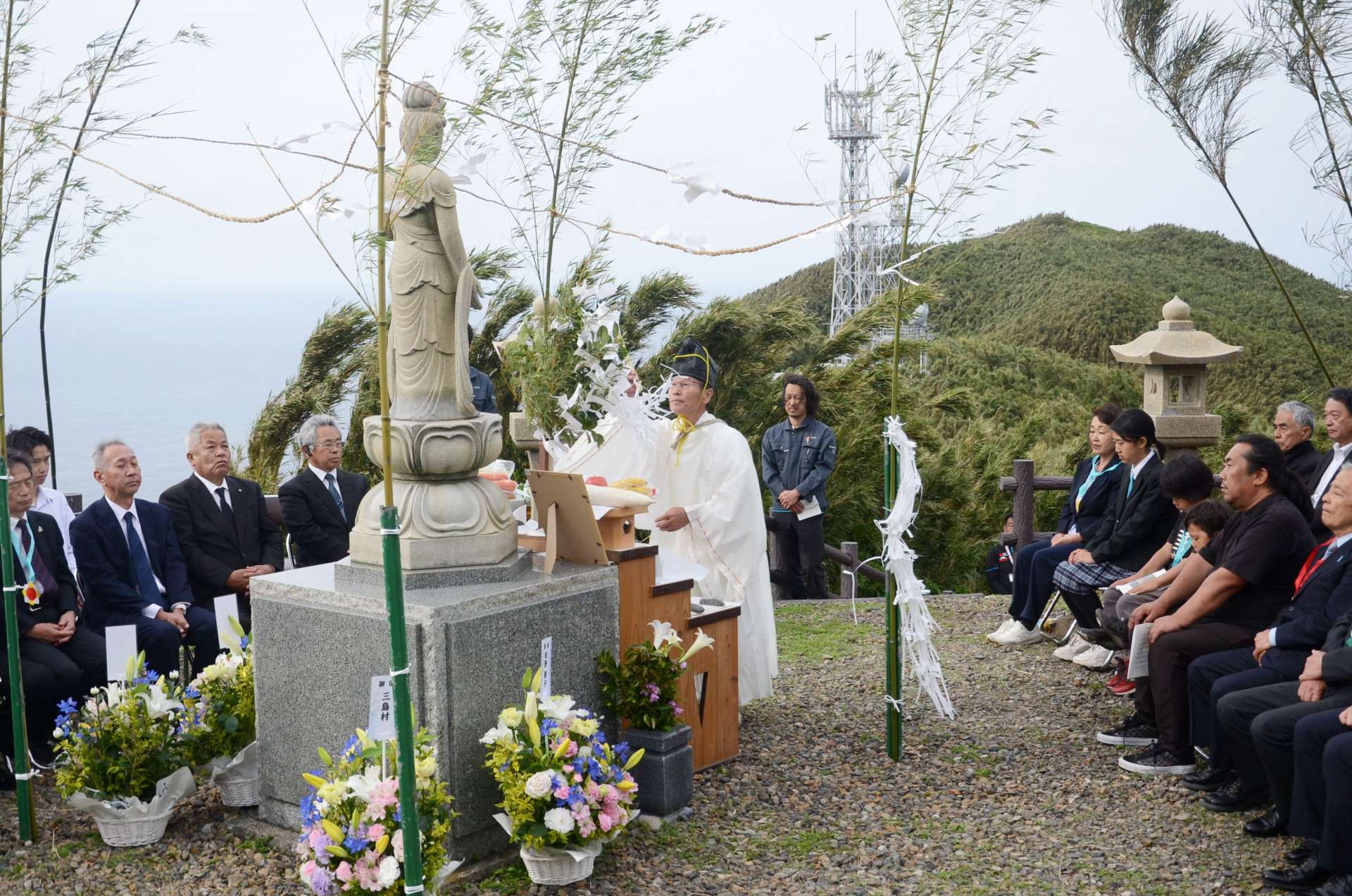 平和観音像の前で平和への祈りをささげる参加者＝１０日、三島村の黒島平和公園