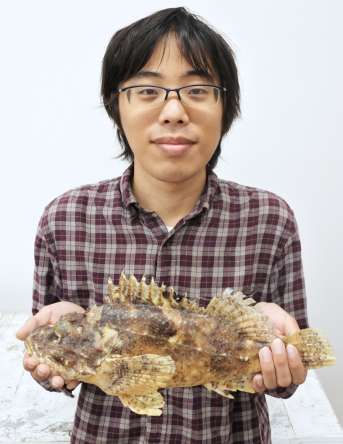 〈関連〉新種と判明したダイオウカサゴの標本を持つ松本達也特任助教＝１３日、鹿児島市の鹿児島大学