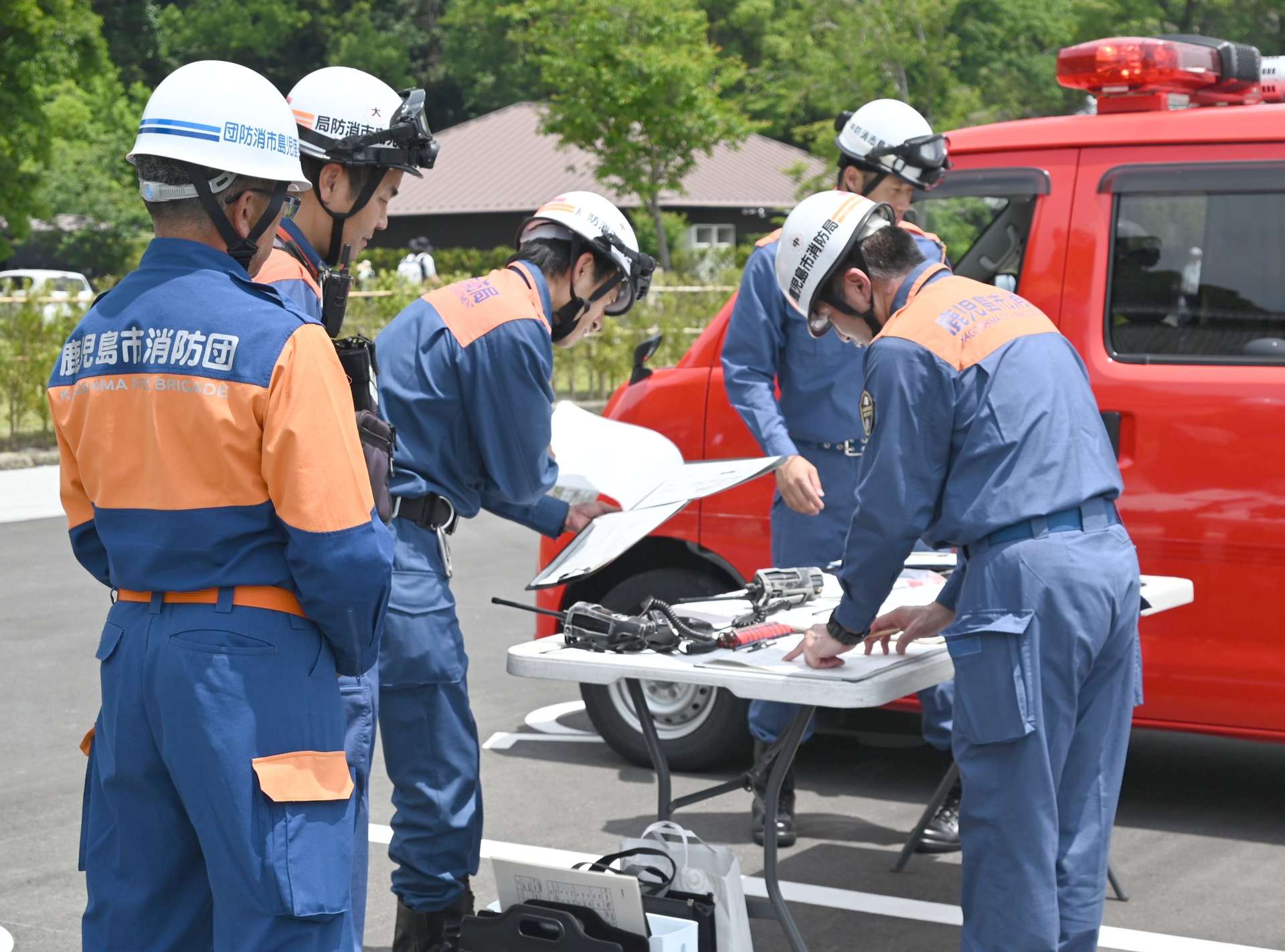 各地区からの報告を受け避難誘導の手順を確認する現地指揮本部＝１５日、鹿児島市吉野町