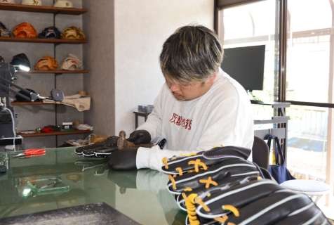ハンマーを使いグラブの形を整える福迫一真さん＝鹿児島市