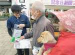 自分たちの写真が入った記念日新聞を受け取る来園者＝鹿屋市のかのやばら園