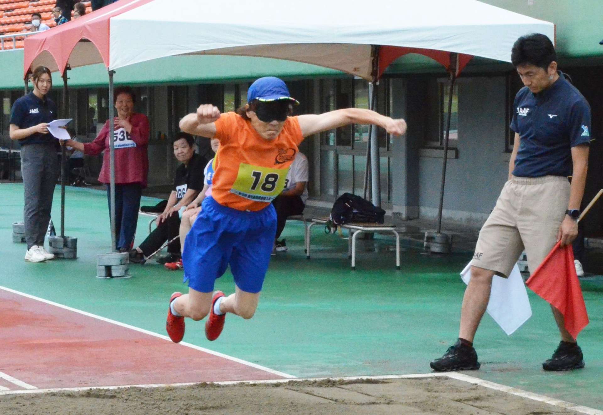 立ち幅跳びで力強く跳躍する選手＝１８日、鹿児島市の白波スタジアム