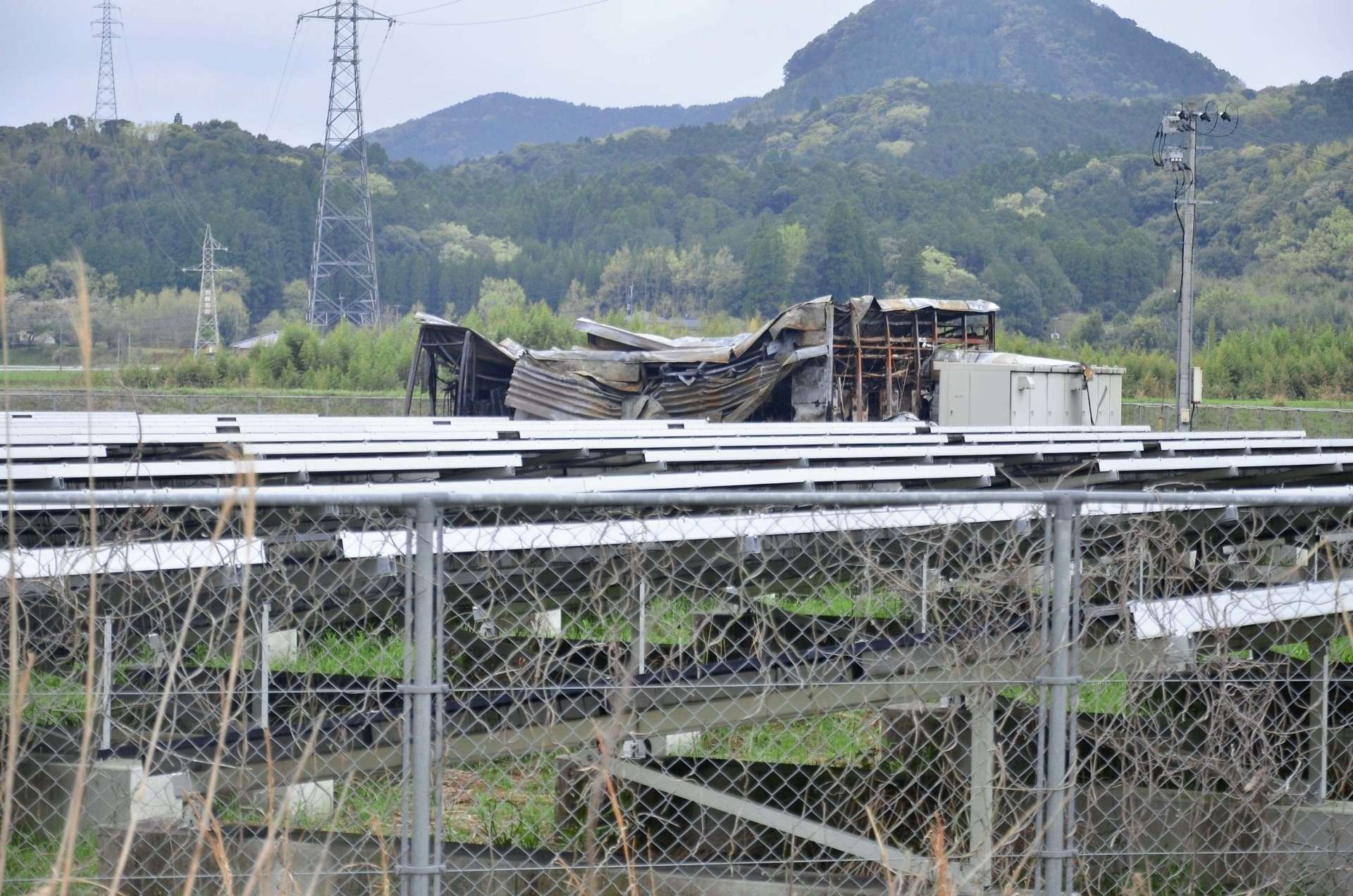 全焼した太陽光発電施設倉庫。周囲にはソーラーパネルが並ぶ＝２０２４年４月４日午後２時２５分ごろ、伊佐市大口大田