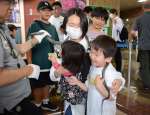 アオダイショウとの触れ合いコーナーを楽しむ来館者＝鹿児島市の県立博物館