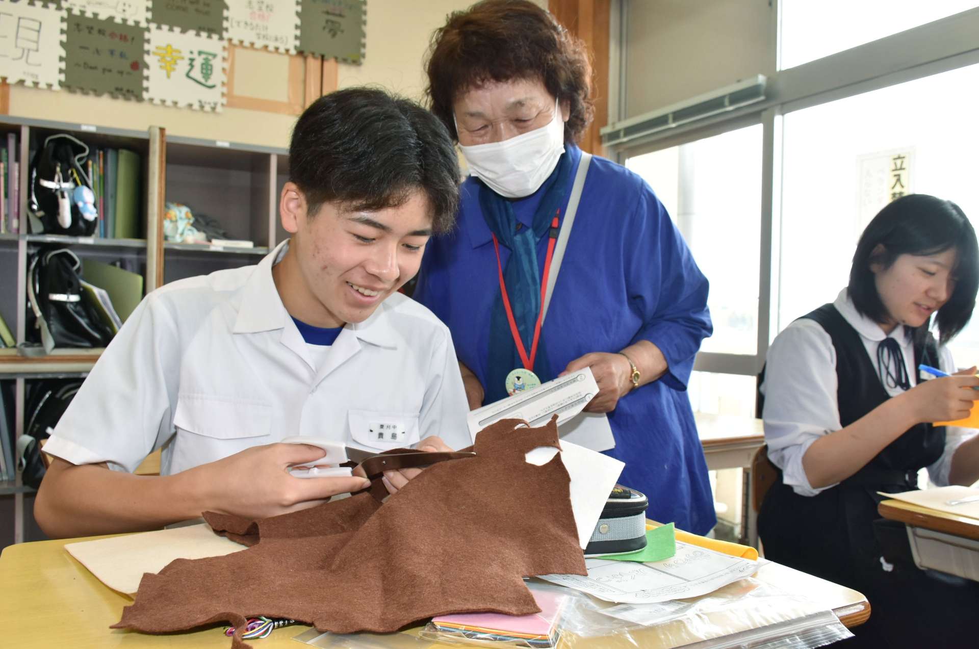 菱刈中サポーターのアドバイスを受け、裁縫を学ぶ生徒＝伊佐市の菱刈中学校