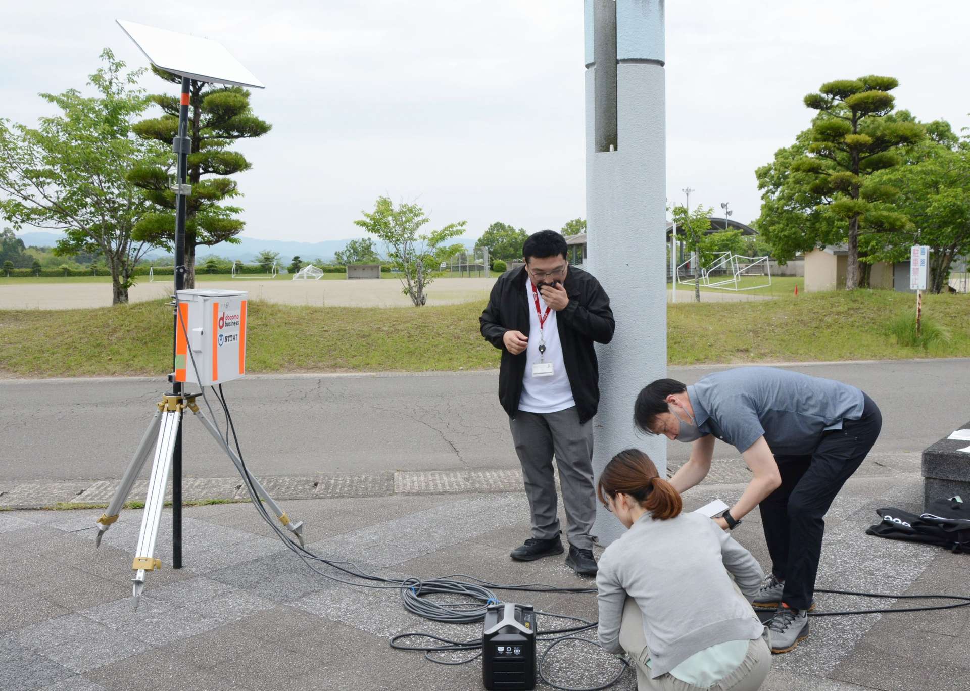 スターリンク用のアンテナ機器を試験的に設置する関係者＝１６日、さつま町船木