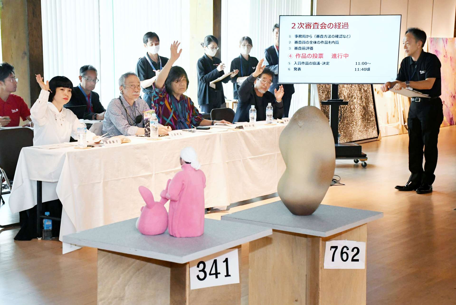 挙手をして入賞作品を決める高畠依子氏（左）ら審査員＝２７日、枕崎市の南溟館