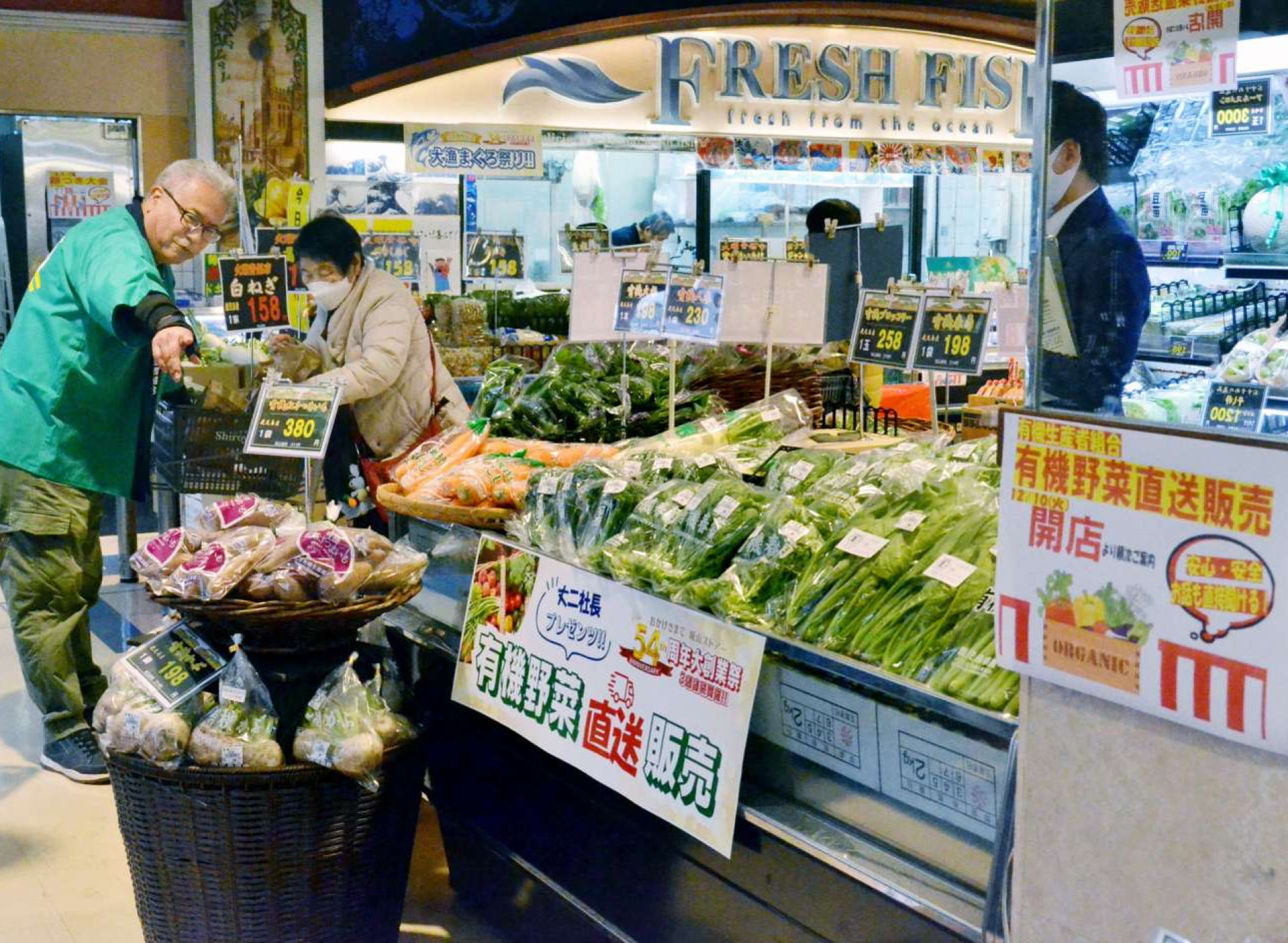 〈資料写真〉有機野菜を来店者へＰＲする関係者＝２０２４年１２月、鹿児島市の城山ストアーフレッセ高見馬場店