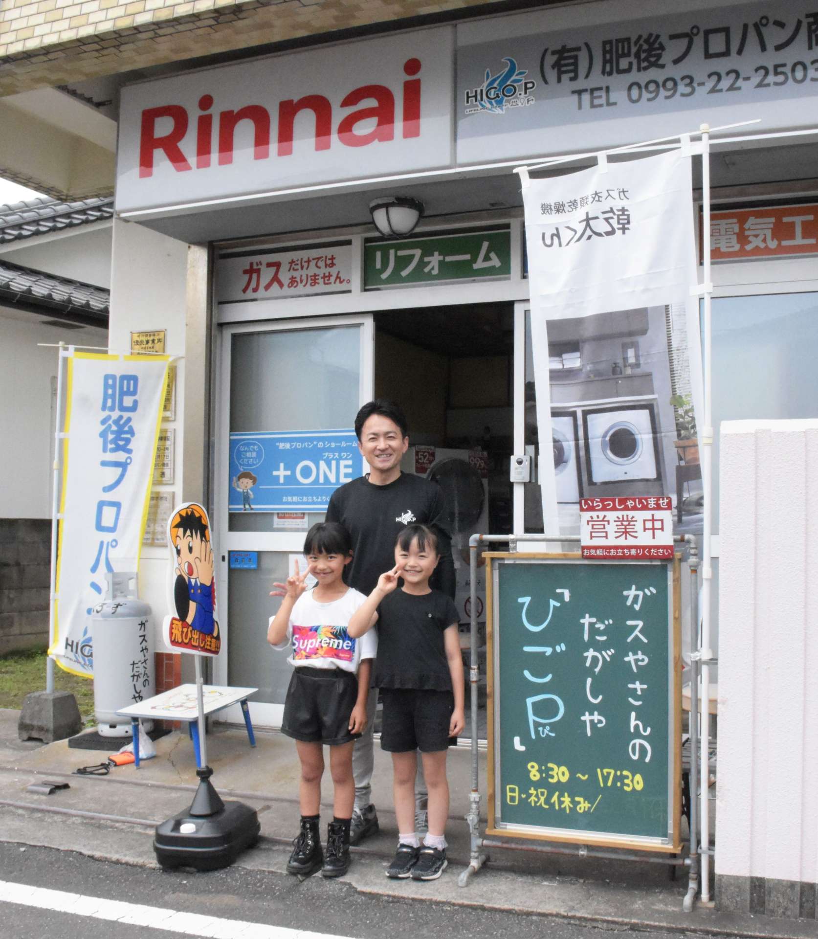 ガス店の一角に駄菓子店を開いた肥後大輔さん（中央）＝２６日、指宿市湊３丁目