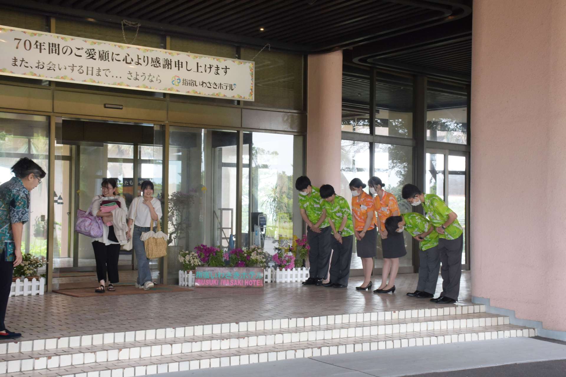 正面玄関に並んで宿泊客を見送る従業員ら＝１日、指宿市の指宿いわさきホテル