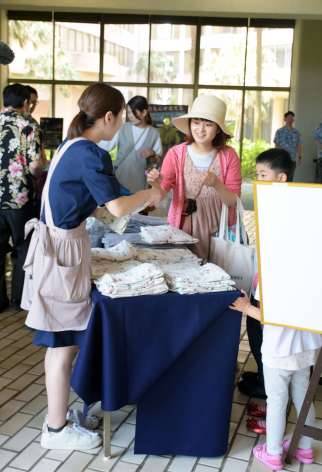ホテルの浴衣やムームーを記念に受け取る宿泊客＝１日、指宿市の指宿いわさきホテル