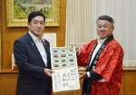 収穫シーズンを迎えた奄美プラムを受け取る塩田康一知事（左）＝２日、県庁
