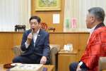 カットされた奄美プラムを味わう塩田康一知事（左）＝２日、県庁