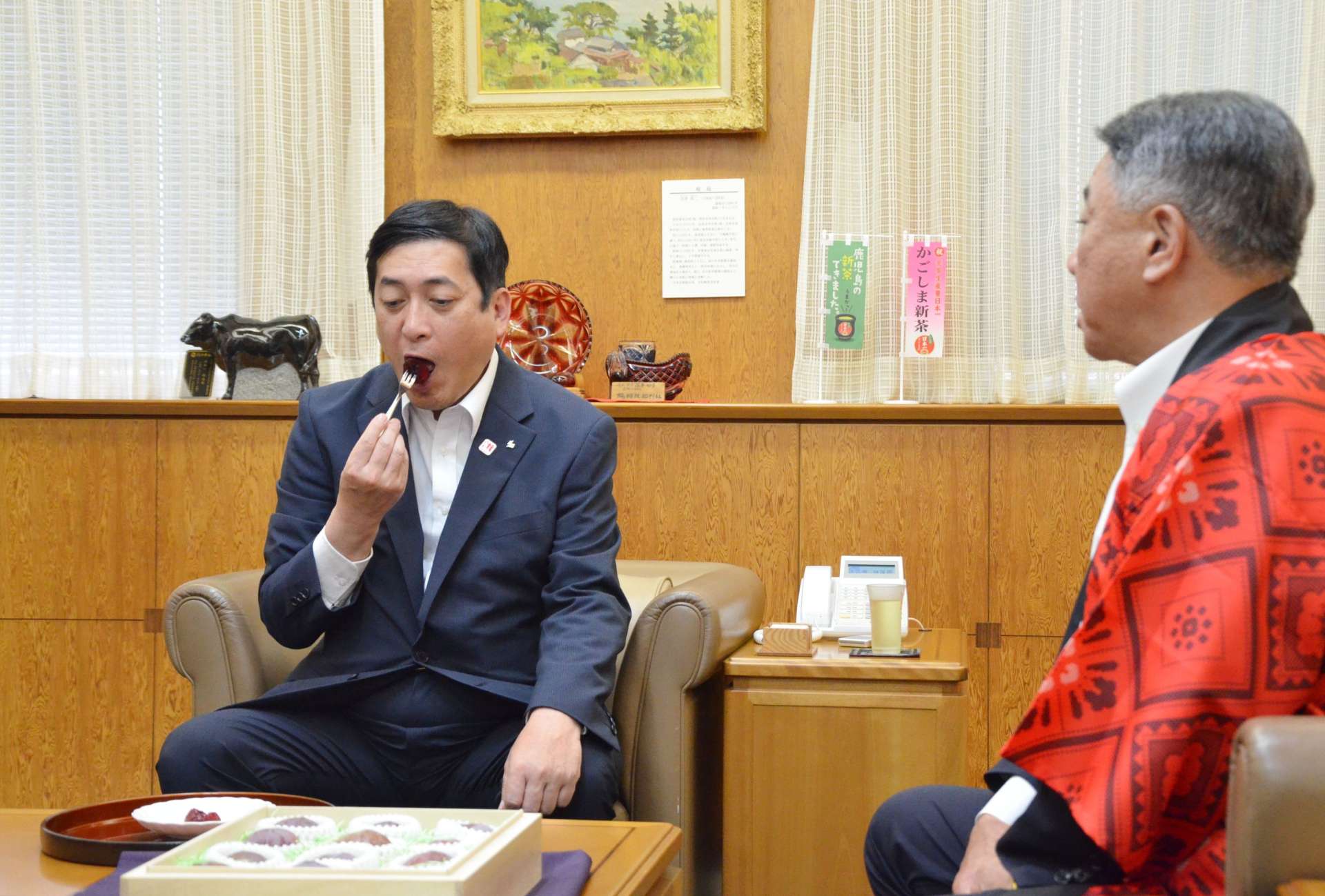 カットされた奄美プラムを味わう塩田康一知事（左）＝２日、県庁