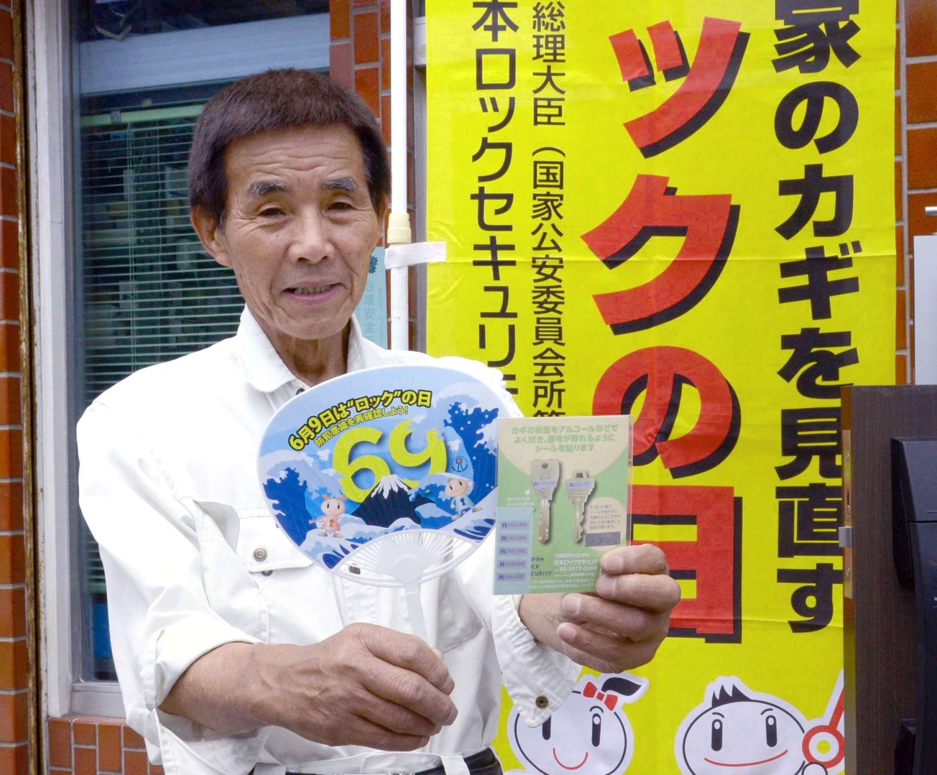啓発グッズを手に「ロックの日」をＰＲする浜田不二夫さん＝７日、鹿児島市鼓川町の浜田ロック