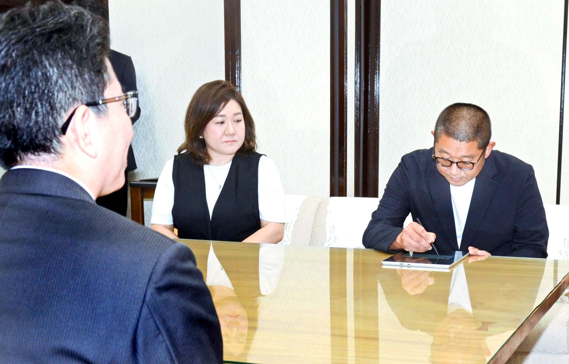 協定書に署名する本坊製茶の本坊敏高社長（右）＝鹿児島市役所