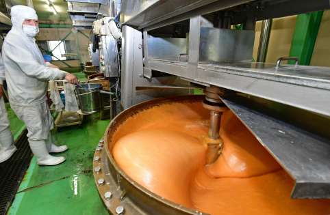 蒸気釜で、もち米や水あめ、ボンタン果汁などの原料を煮詰めながらかき混ぜる。辺りには甘い香りが漂っている