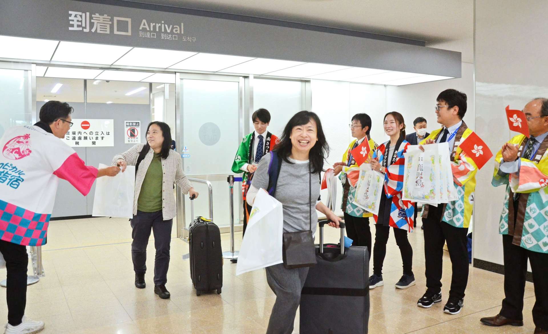 新型コロナウイルス禍後の香港航空の再開第１便で、歓迎を受ける香港の観光客＝２０２４年３月３１日、霧島市の鹿児島空港国際線ターミナル
