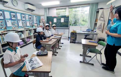〈関連〉ヘルメットを着けて授業を受ける子どもたち＝２３日午前８時１５分ごろ、十島村悪石島の悪石島学園（同学園提供）