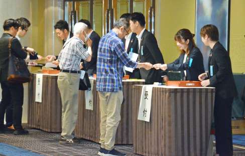 九州電力の株主総会で受け付けをする株主＝２６日、福岡市