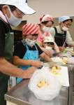 ポリ袋（手前）に入れる材料を切る児童ら＝南さつま市民センター