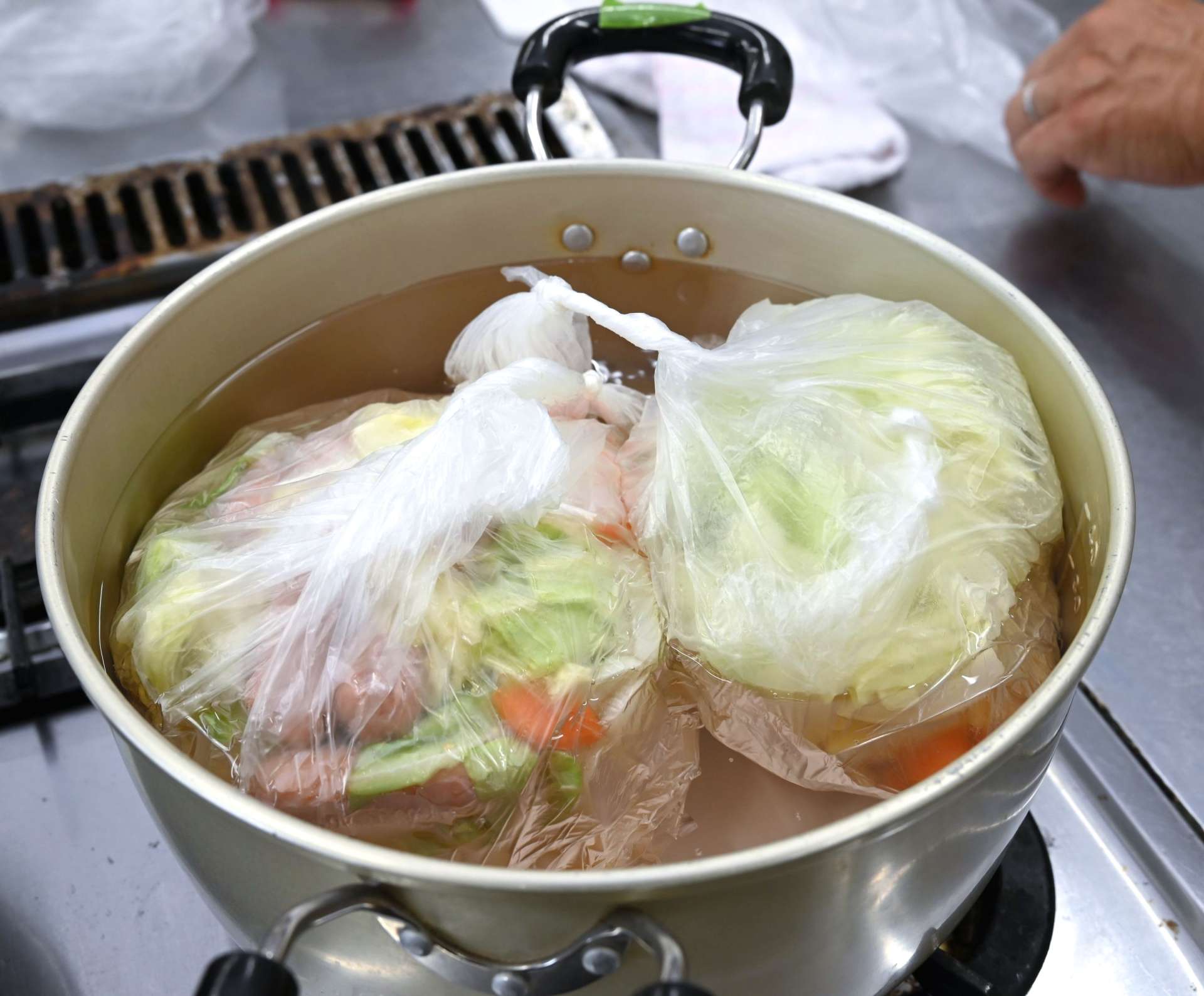 ポリ袋に材料を入れて湯煎するポトフ作り＝南さつま市民センター