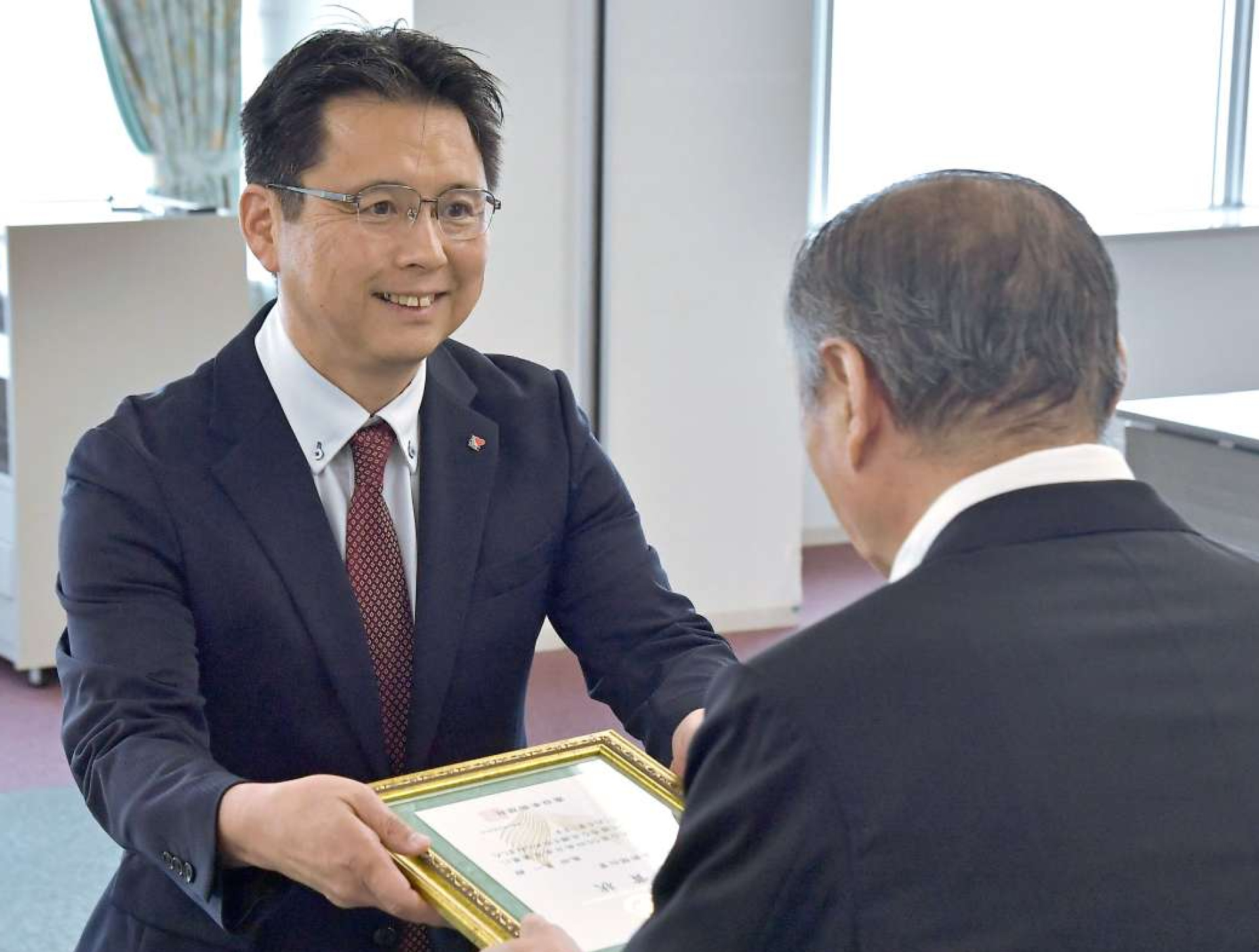 南日本新聞社賞を受ける亀田晃一さん＝２７日、南日本新聞会館