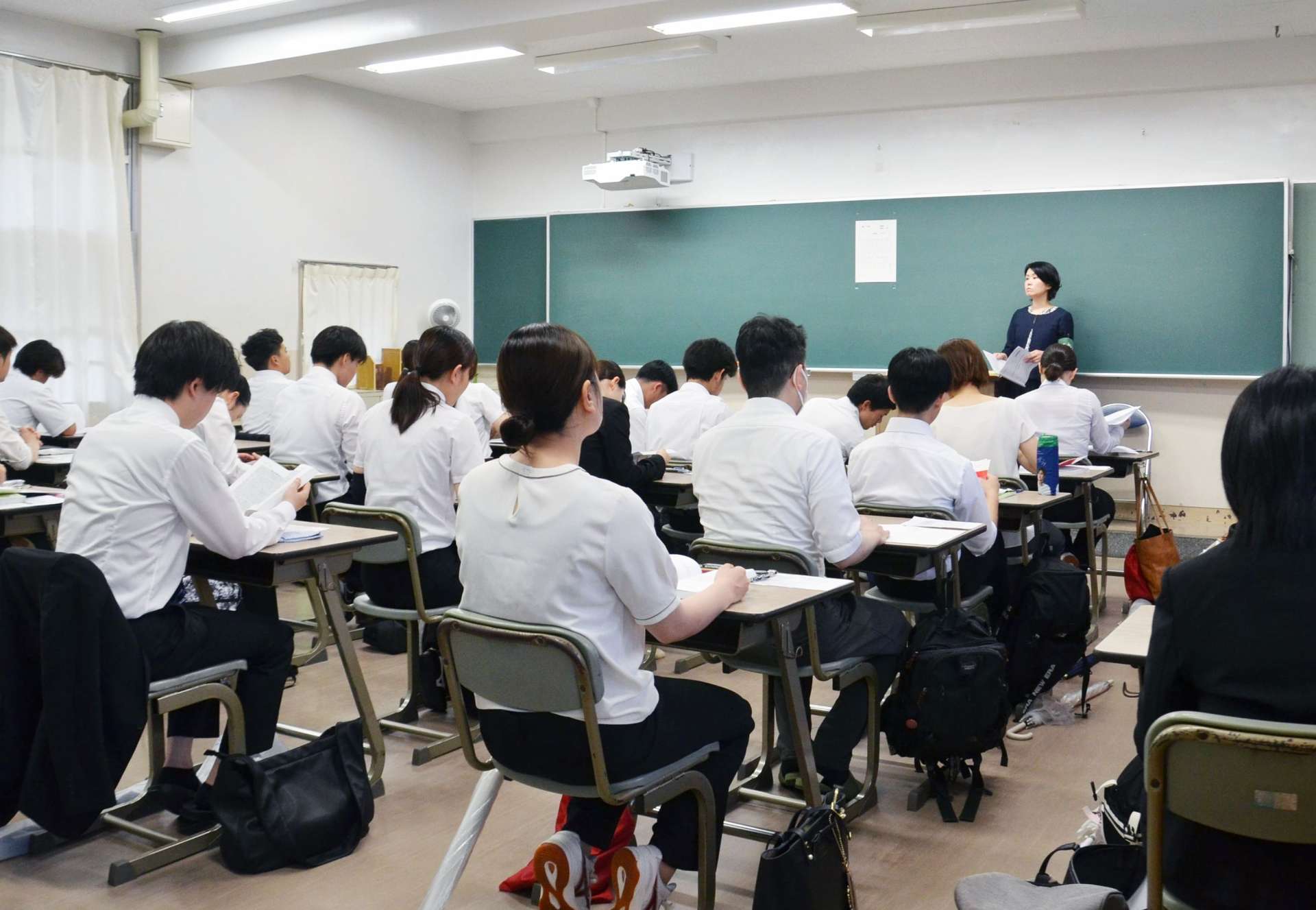 教員採用試験に臨む受験者。昨年から大学３年生が一部の試験を受けられるようになった＝１５日朝、鹿児島市の鶴丸高校