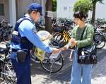 詐欺被害防止へ「大人のいかのおすし」を周知する警察官＝６月２０日、鹿児島市の鹿児島大学
