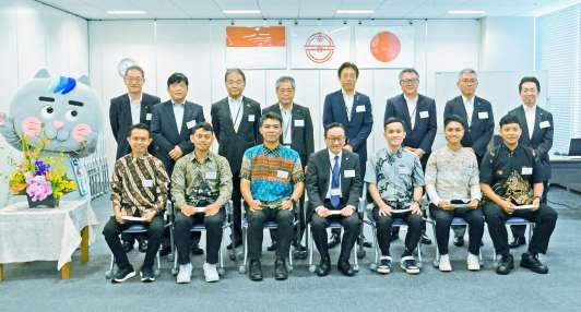 南国交通の入社式で記念撮影する役員と特定技能の新入社員ら＝１日、鹿児島市の同社