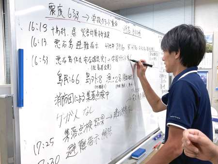 〈続々と入る情報〉ホワイトボードに書き込む十島村職員＝３日、鹿児島市の村役場
