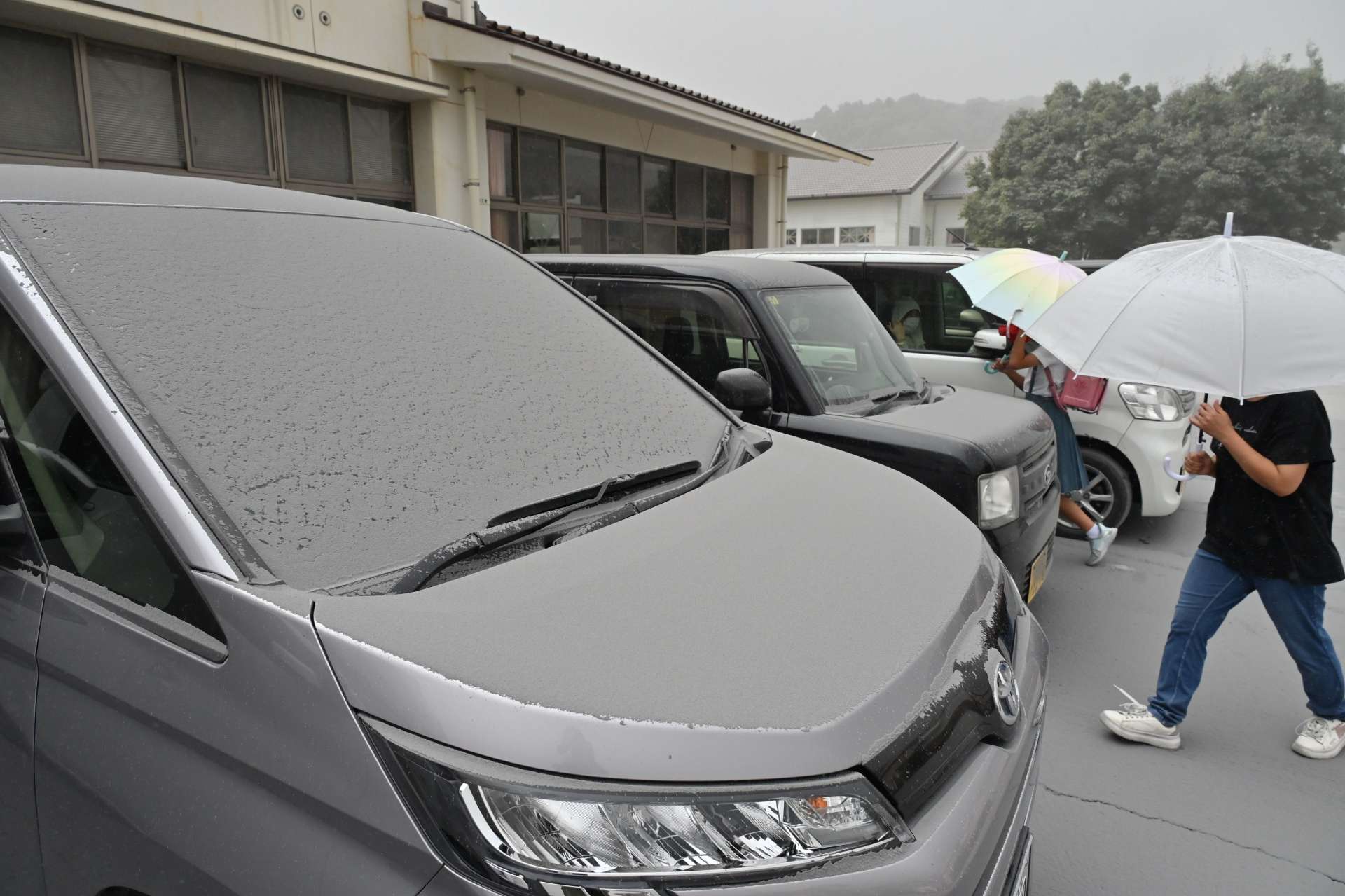 車のボンネットに積もった火山灰＝３日午後４時、霧島市牧園町の高千穂小学校