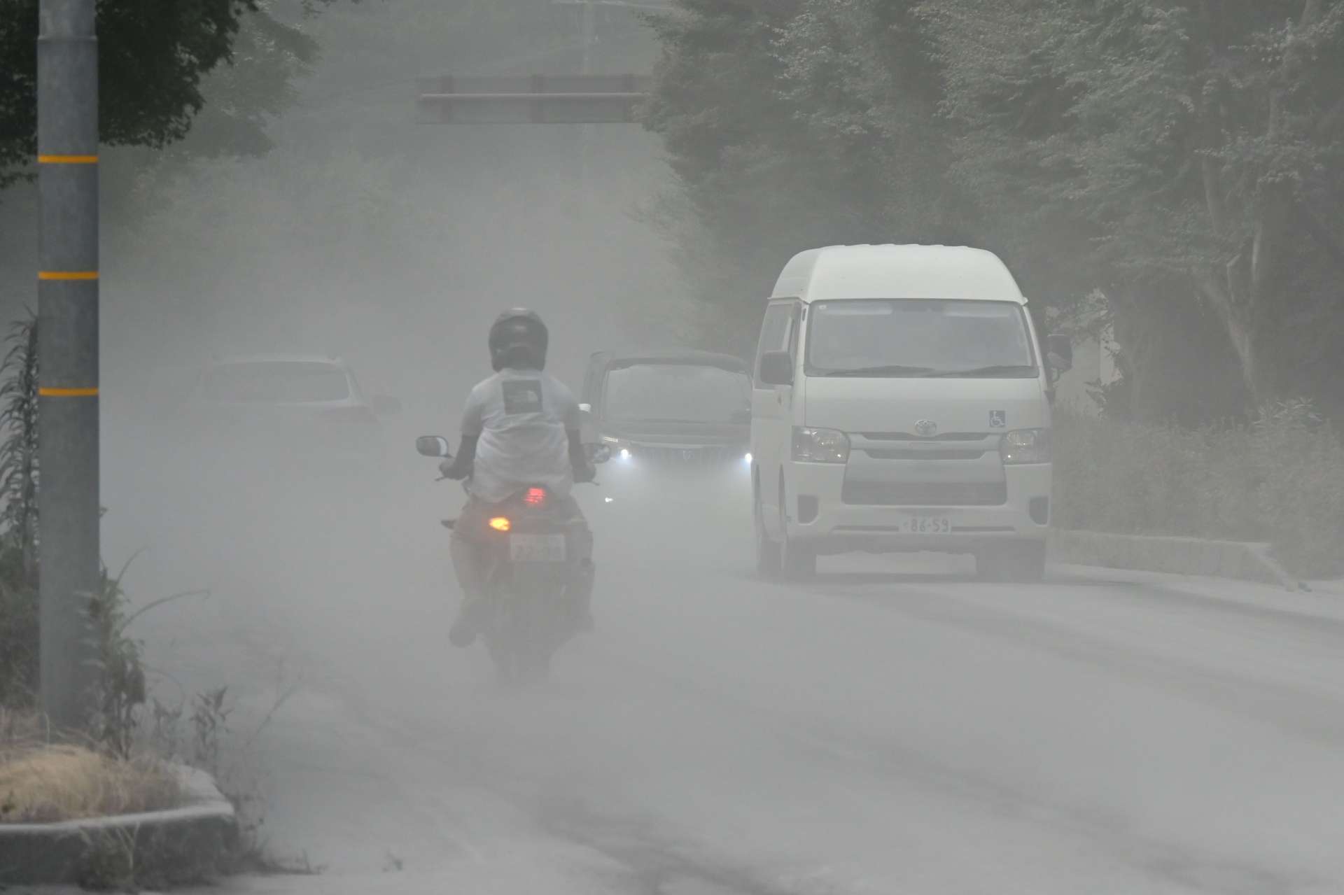 舞い上がった灰で見通しが悪くなった道路＝３日午後４時半、霧島市牧園町高千穂