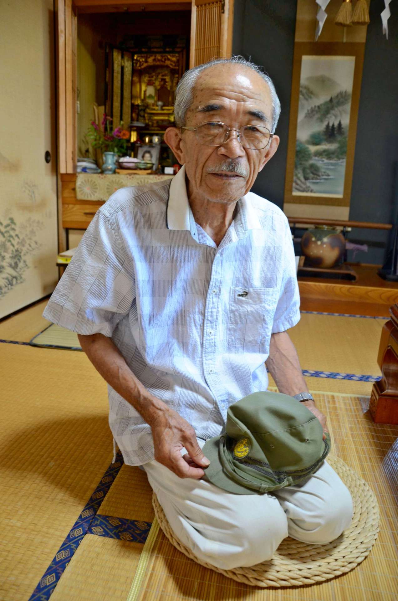 陸戦隊時代の帽子を手に記憶をたどる白川節夫さん＝えびの市昌明寺