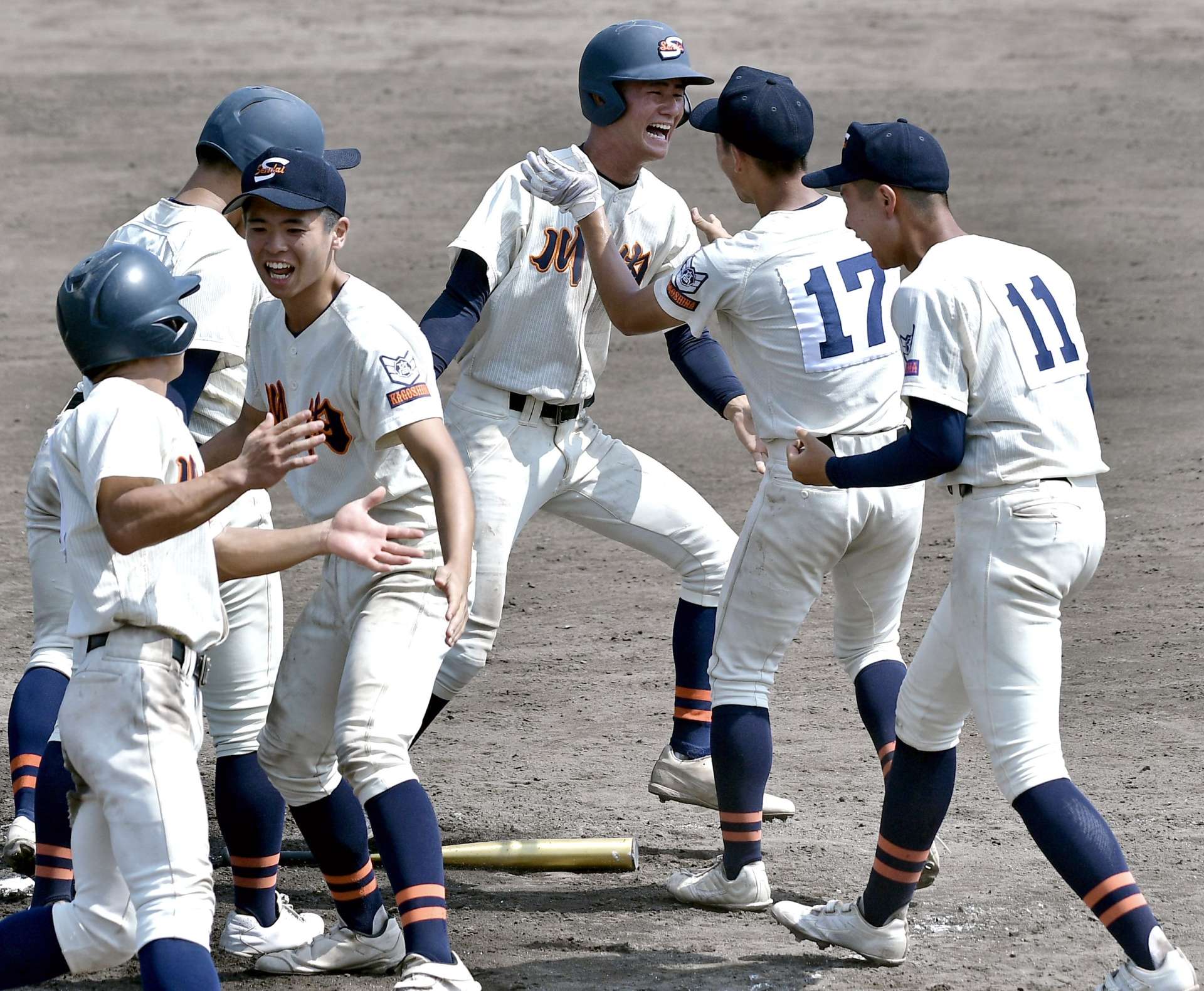 延長１０回裏タイブレークでサヨナラのホームを踏み喜ぶ吉田勝（中央）と川内ナイン＝鴨池市民（田中公人撮影）