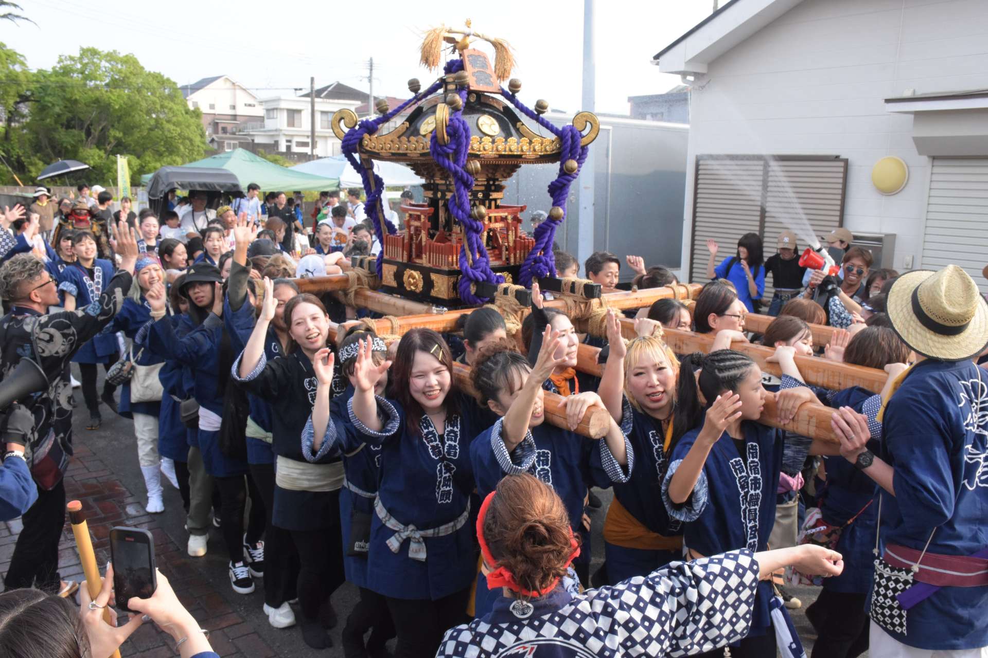 威勢よくみこしを担ぐ女性たち＝指宿市湯の浜５丁目