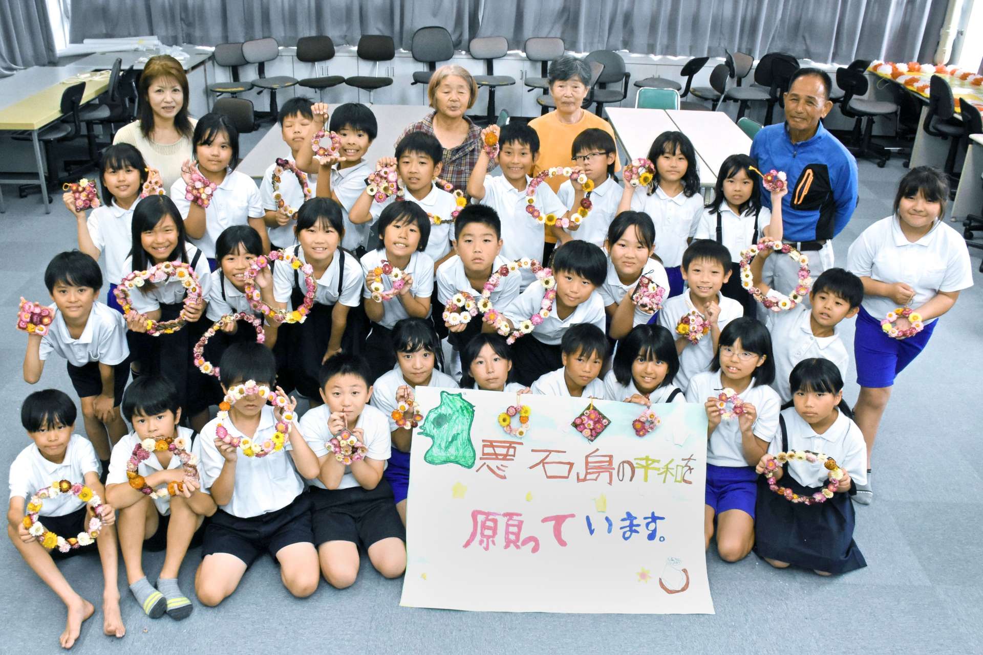 悪石島の子どもにリース飾りと横断幕を作った児童ら＝１０日、出水市の下水流小学校