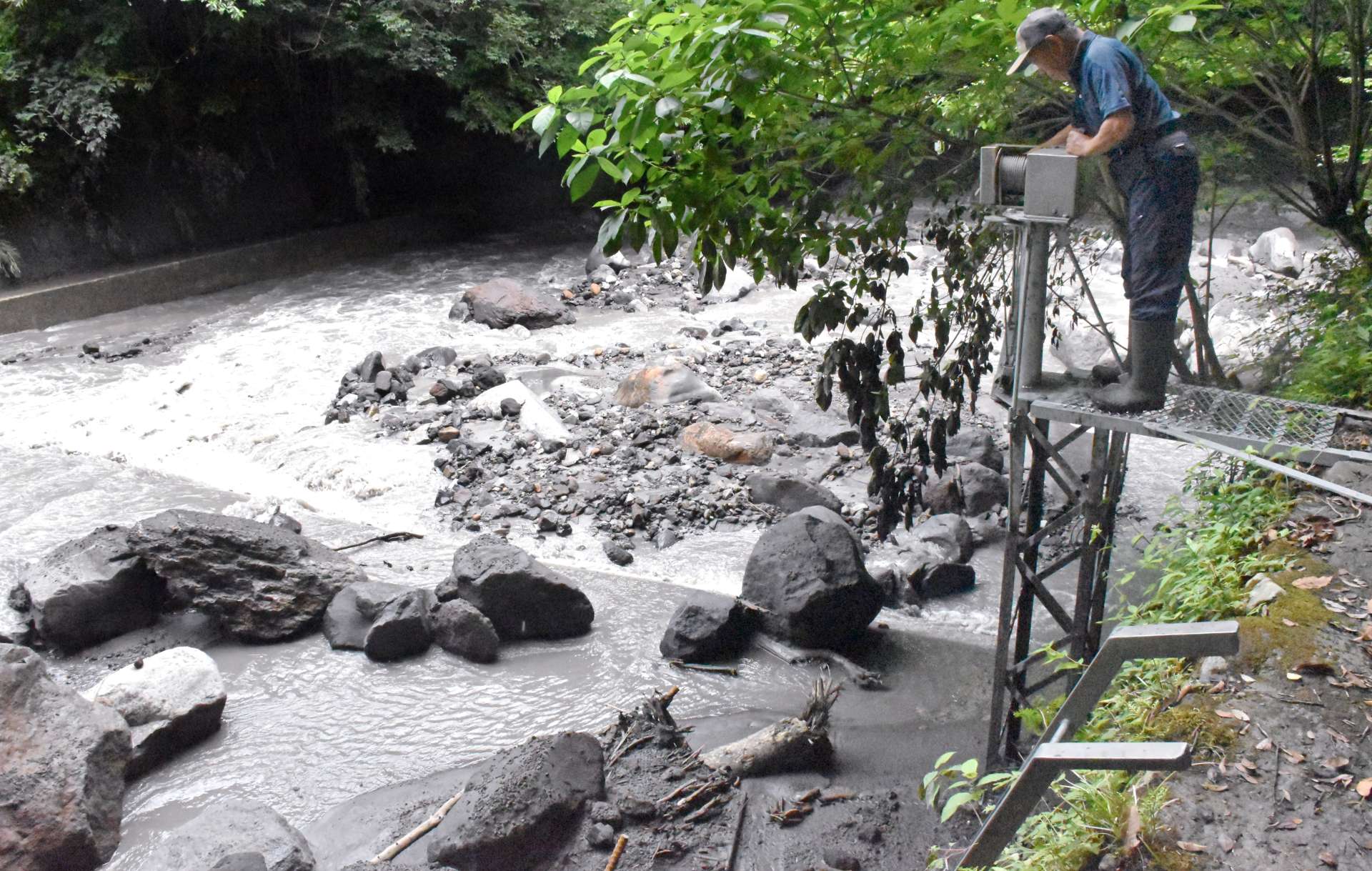〈火山灰などでふさがれた取水口付近〉を確認する水利組合の関係者＝１２日、霧島市霧島田口の霧島川