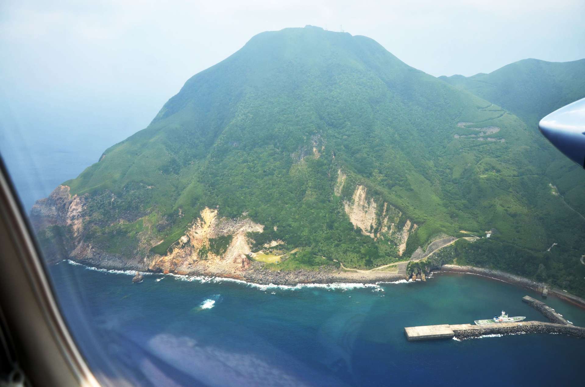 悪石島やすら浜港付近。地震の影響か、山肌があらわになった斜面が見える＝９日午後１時５分、十島村悪石島