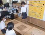 児童クラブで将棋の腕を磨く児童ら。５年の塩手遥之さん（奥）が選手兼指導役を担う＝指宿市山川の山川児童クラブ