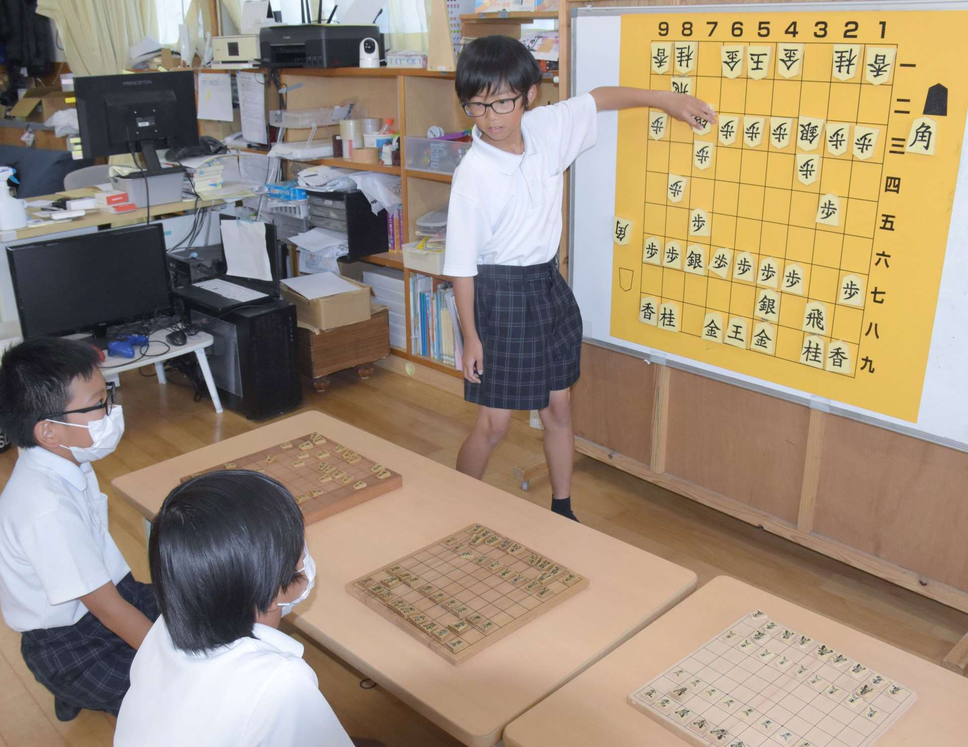 児童クラブで将棋の腕を磨く児童ら。５年の塩手遥之さん（奥）が選手兼指導役を担う＝指宿市山川の山川児童クラブ
